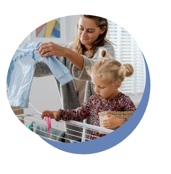 Junge Frau und kleines Kind hängen zusammen Wäsche auf