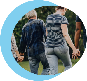 Gruppe Erzieher:innen halten sich in einer Reihe an der Hand